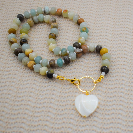 A beaded necklace with natural abacus amazonite stones and a white mother pearl heart