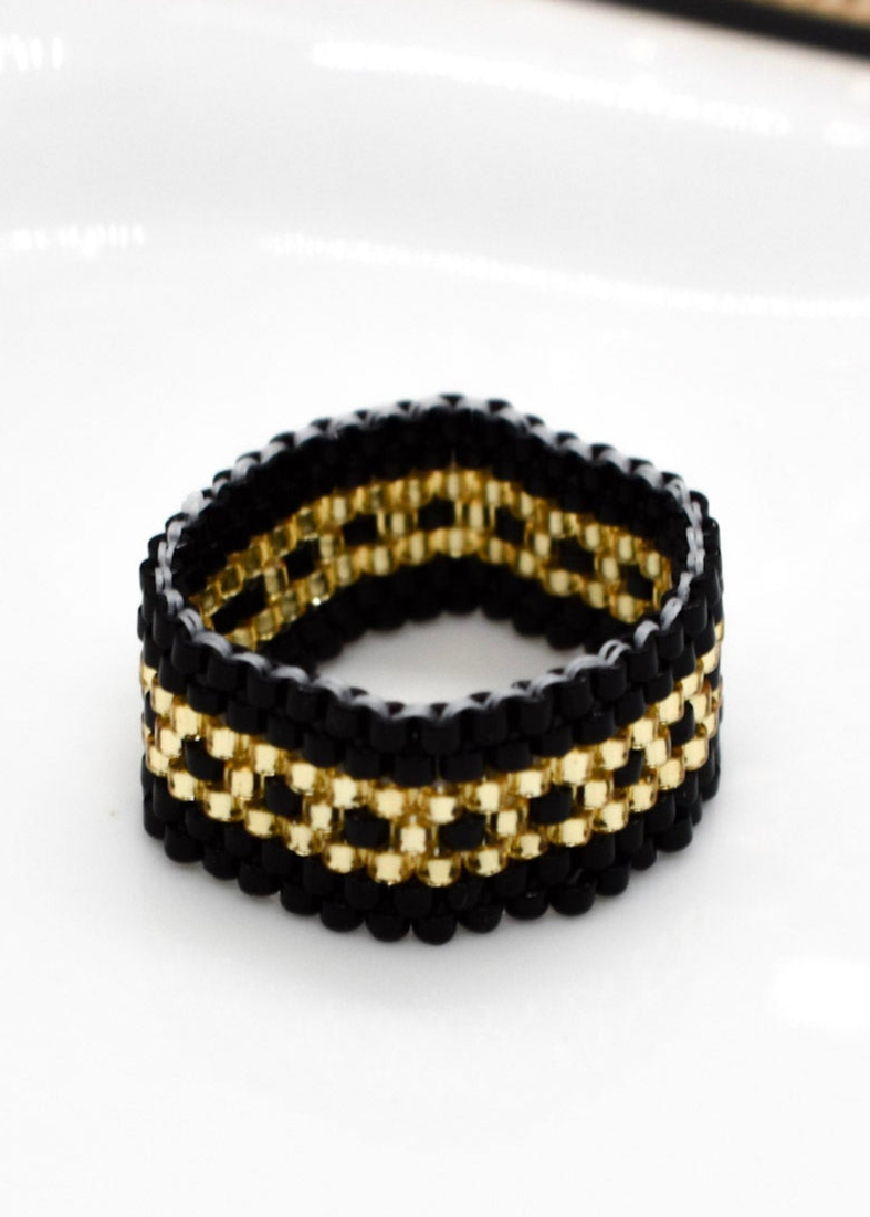Black and gold beaded bracelet on a white background