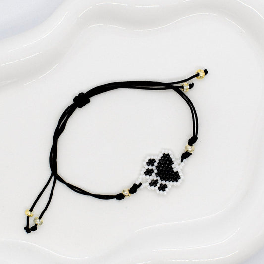 Black beaded paws bracelet on a white tray