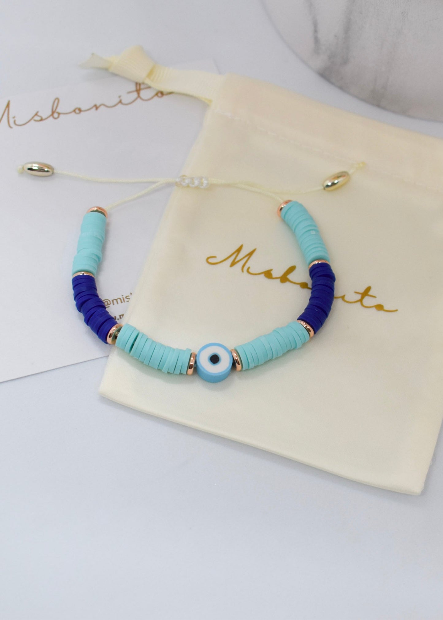 Bracelet with blue heishi beads on a 'Misbonito' branded pouch