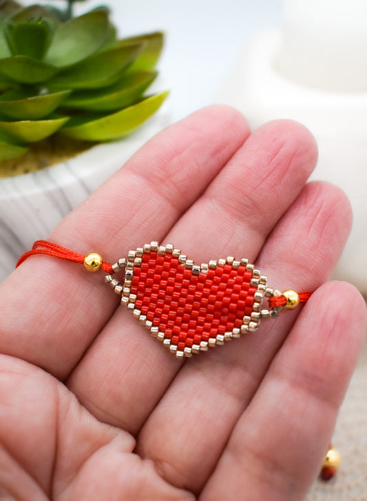 Red heart-shaped beaded bracelet on a hand
