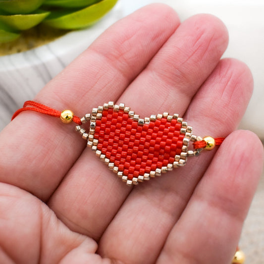 Red heart-shaped beaded bracelet on a hand