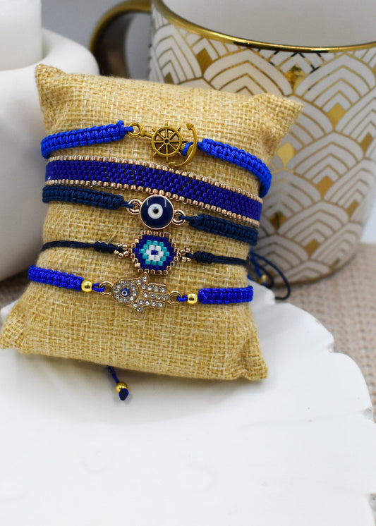 Hand holding a small beaded bracelet with a geometric design on a plain background