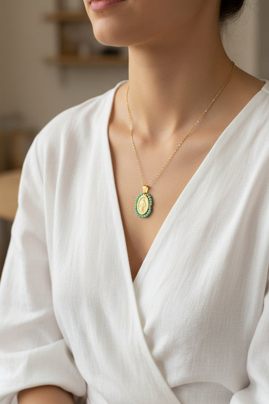 Gold necklace with a green pendant on a white background