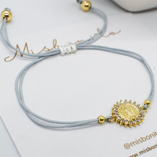 Gray bracelet with gold charm on a white card with 'misbonito' branding