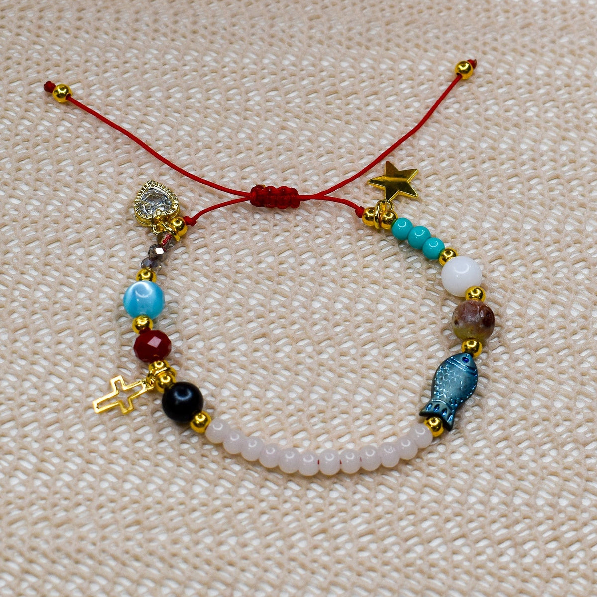 Beaded bracelet with charms on a textured beige surface