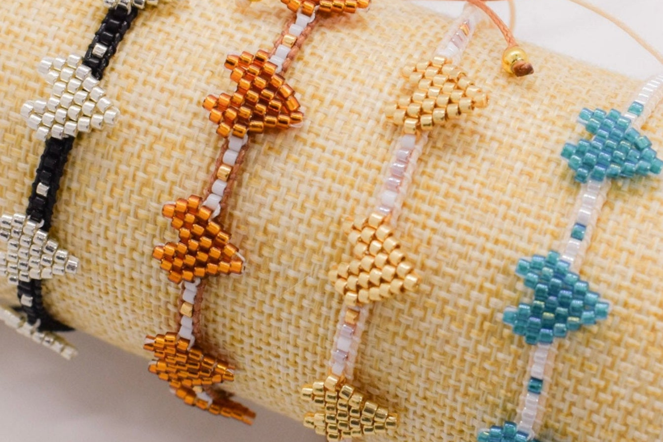 Close-up of beaded bracelets with geometric patterns on a textured surface.