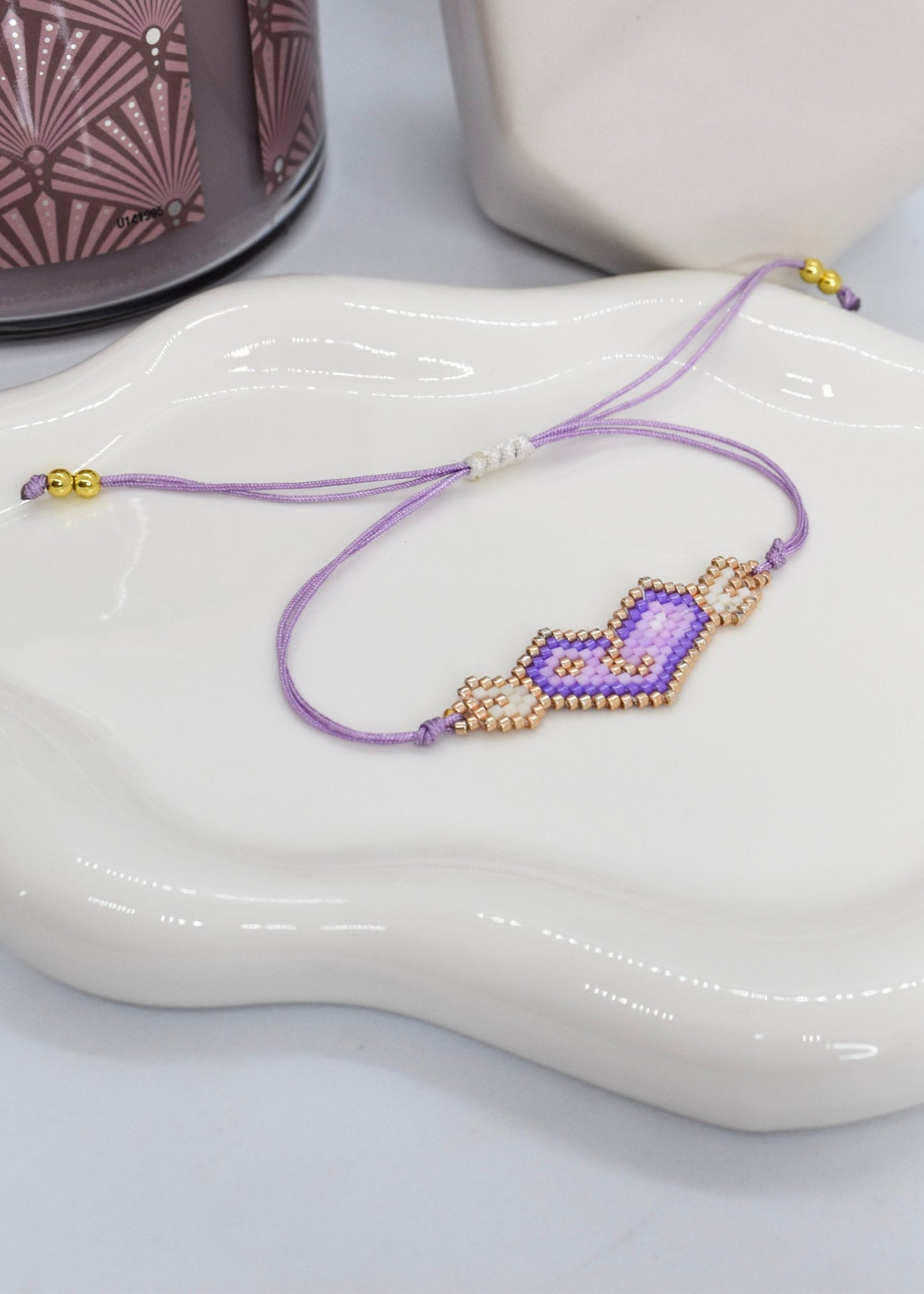 Purple wings adjustable bracelet on a white irregular tray