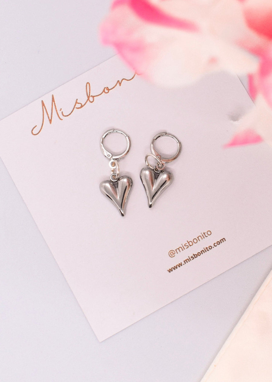 Silver heart-shaped earrings on a Misbonito branded card with floral background