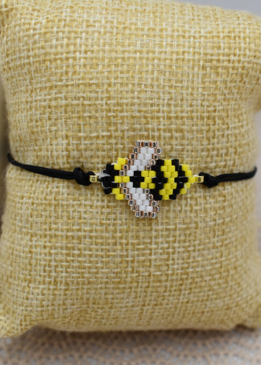 Bracelet with a bee design on a textured pillow