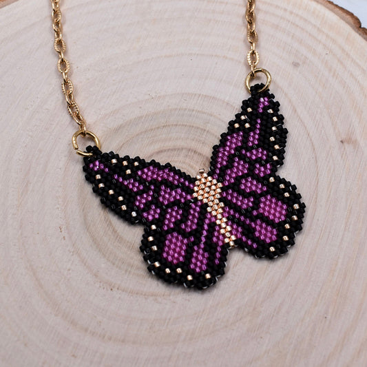 beaded butterfly necklace purple on a wood surface