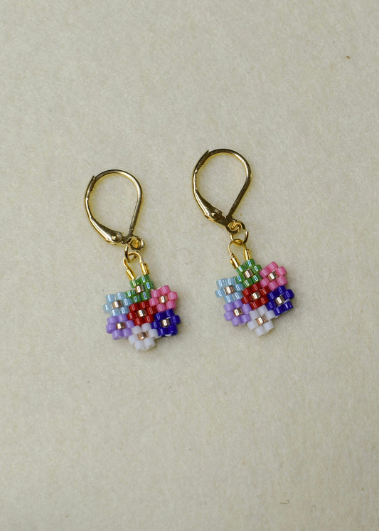 Pair of beaded flower earrings on a beige background