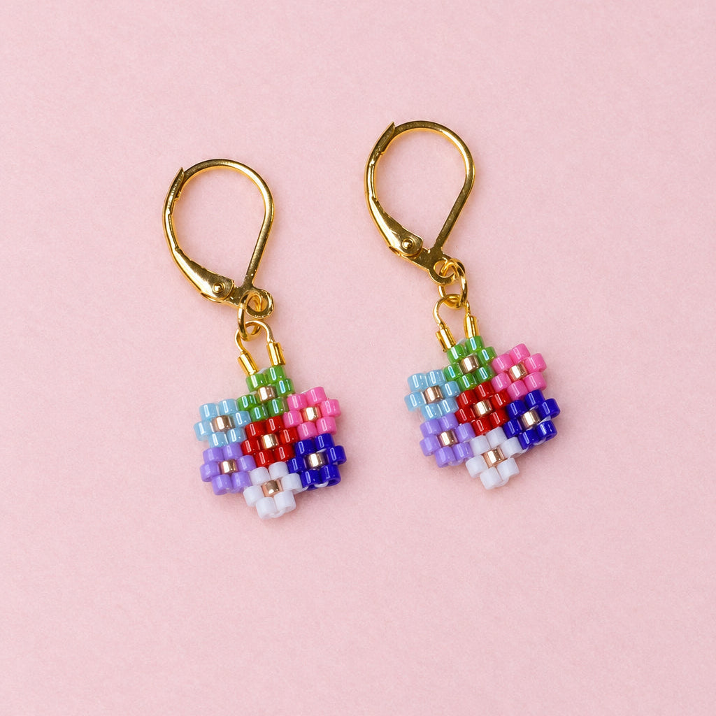 Pair of beaded flower earrings on a beige background