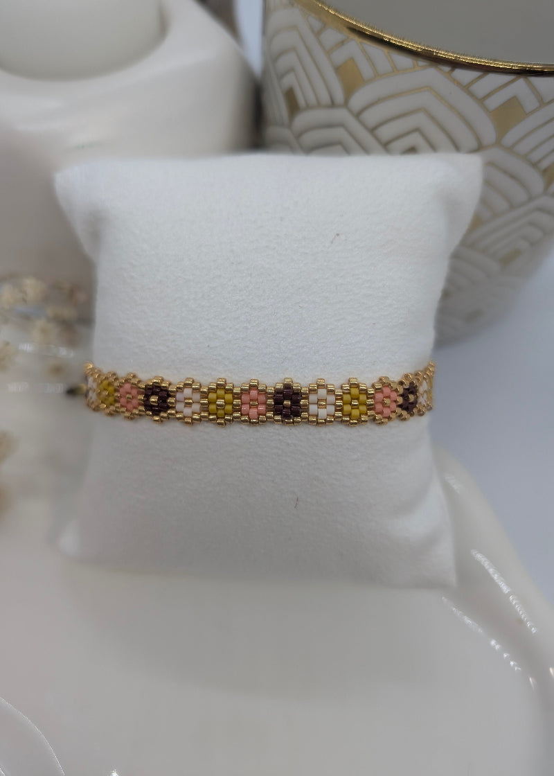 Beaded bracelet on a white cushion with a decorative background