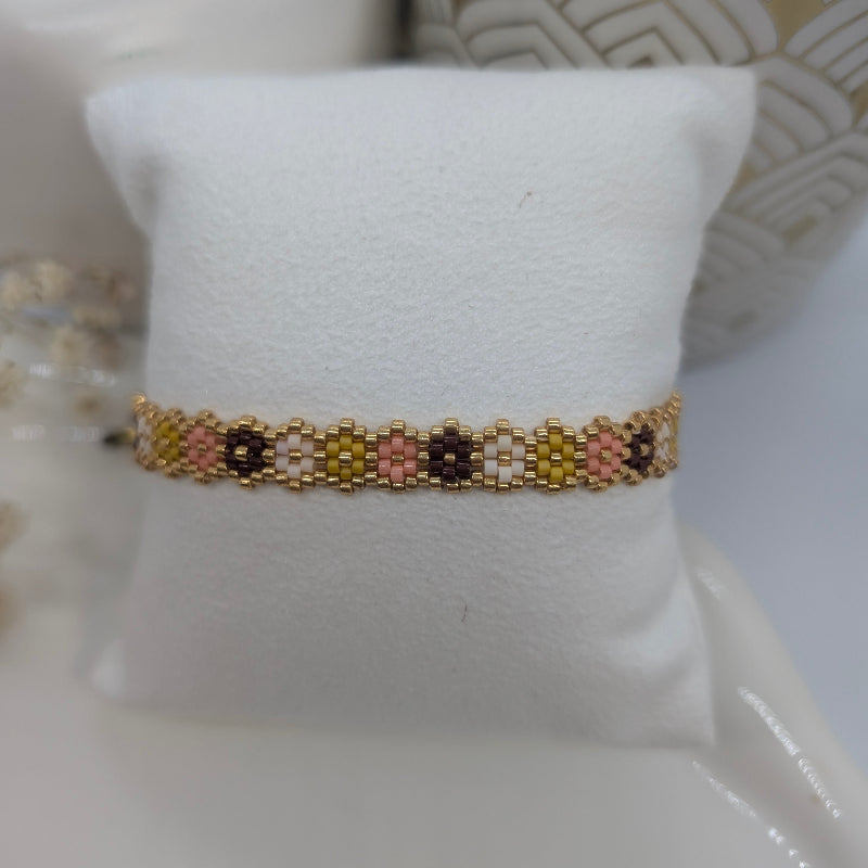 Beaded bracelet on a white cushion with a decorative background