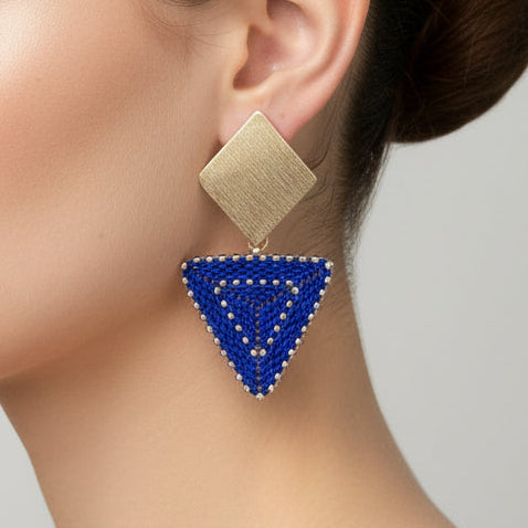 Gold and blue beaded triangle earrrings on a model