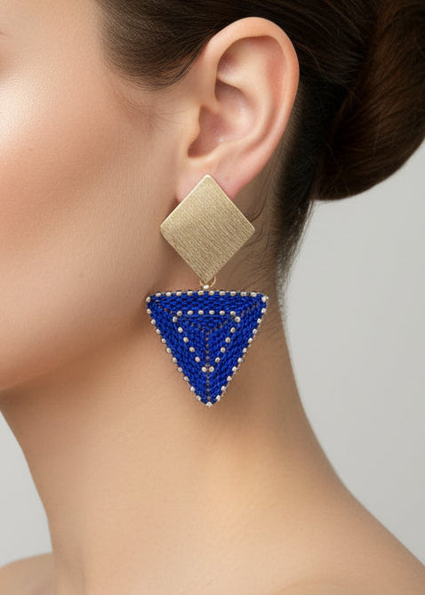 Gold and blue beaded triangle earrrings on a model