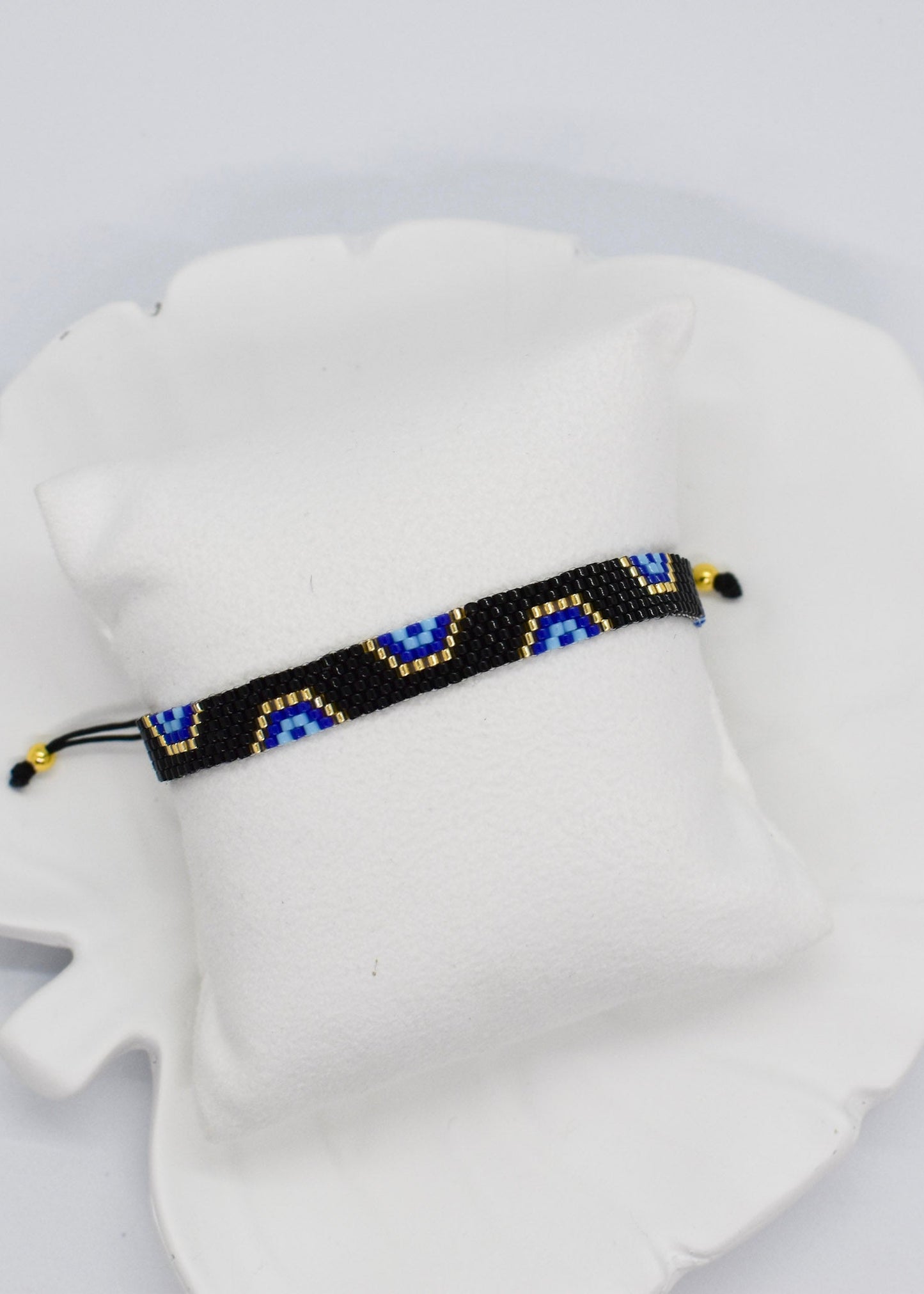 evil eye bar black bracelet on a white display pillow