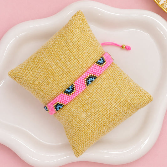 evil eye bar bracelet pink bar on a pillow display