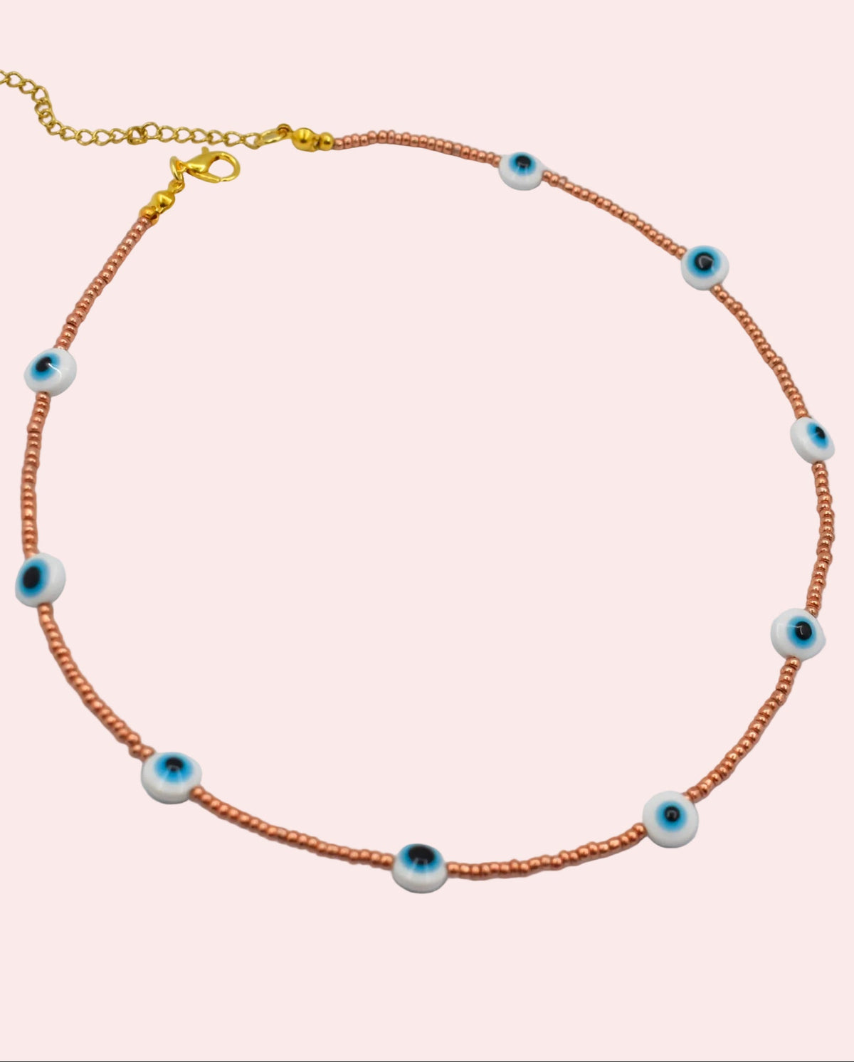 evil eye golden necklace on a white surface
