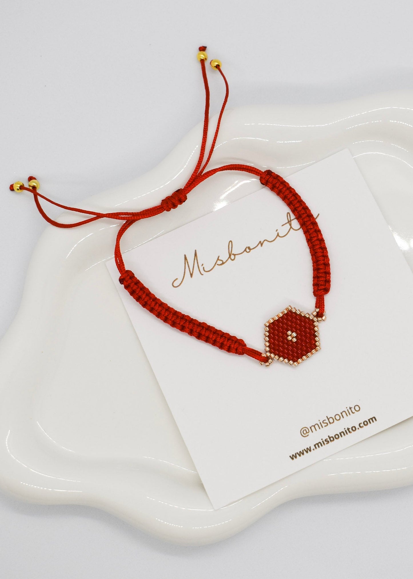 Brown bracelet with hexagonal bead on a white card with 'Misbonito' branding.