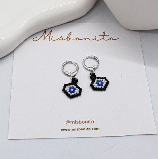 evil eye earrings with a decorative design on a 'Misbonito' branded card.