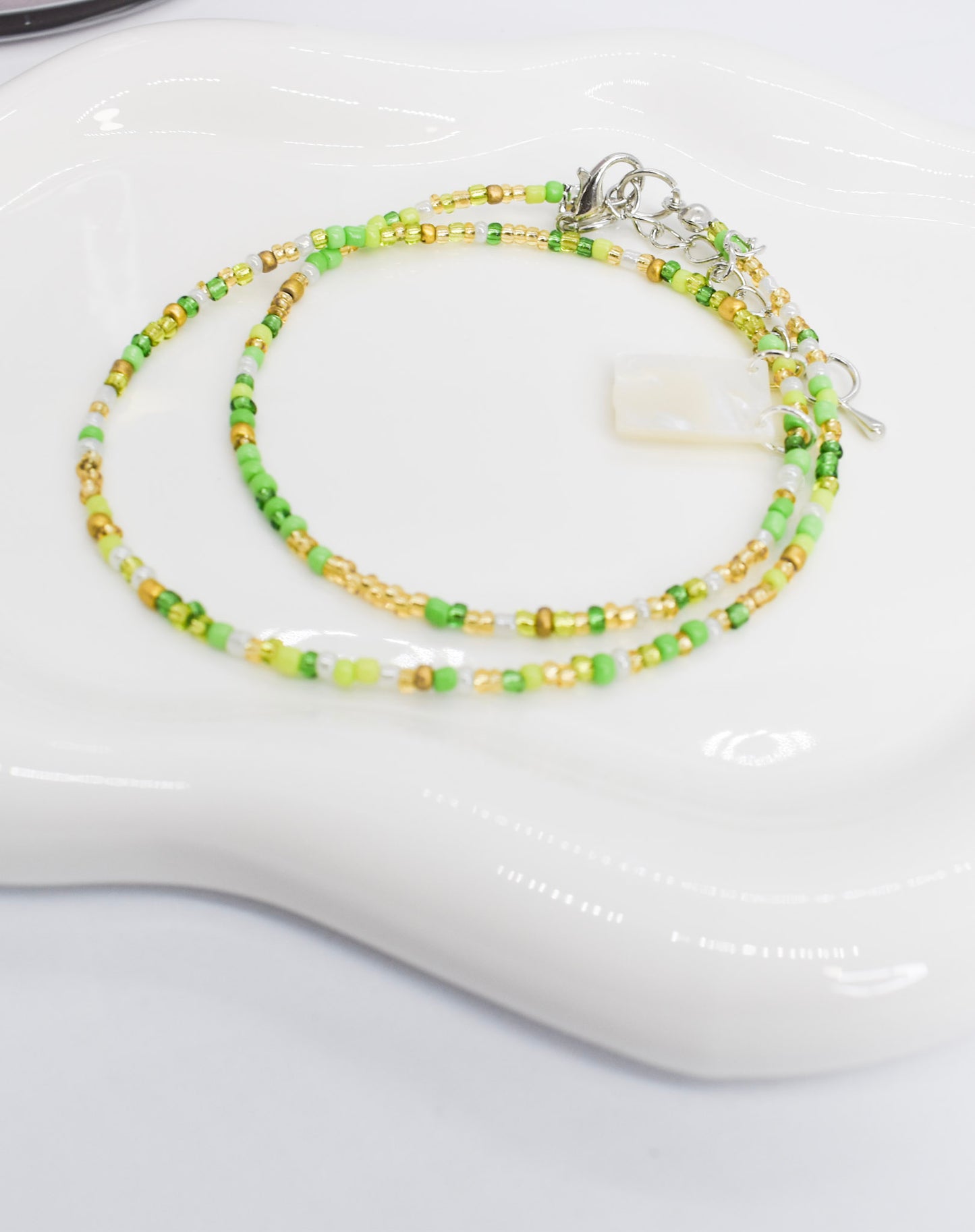 green necklace with white scapular on a tray