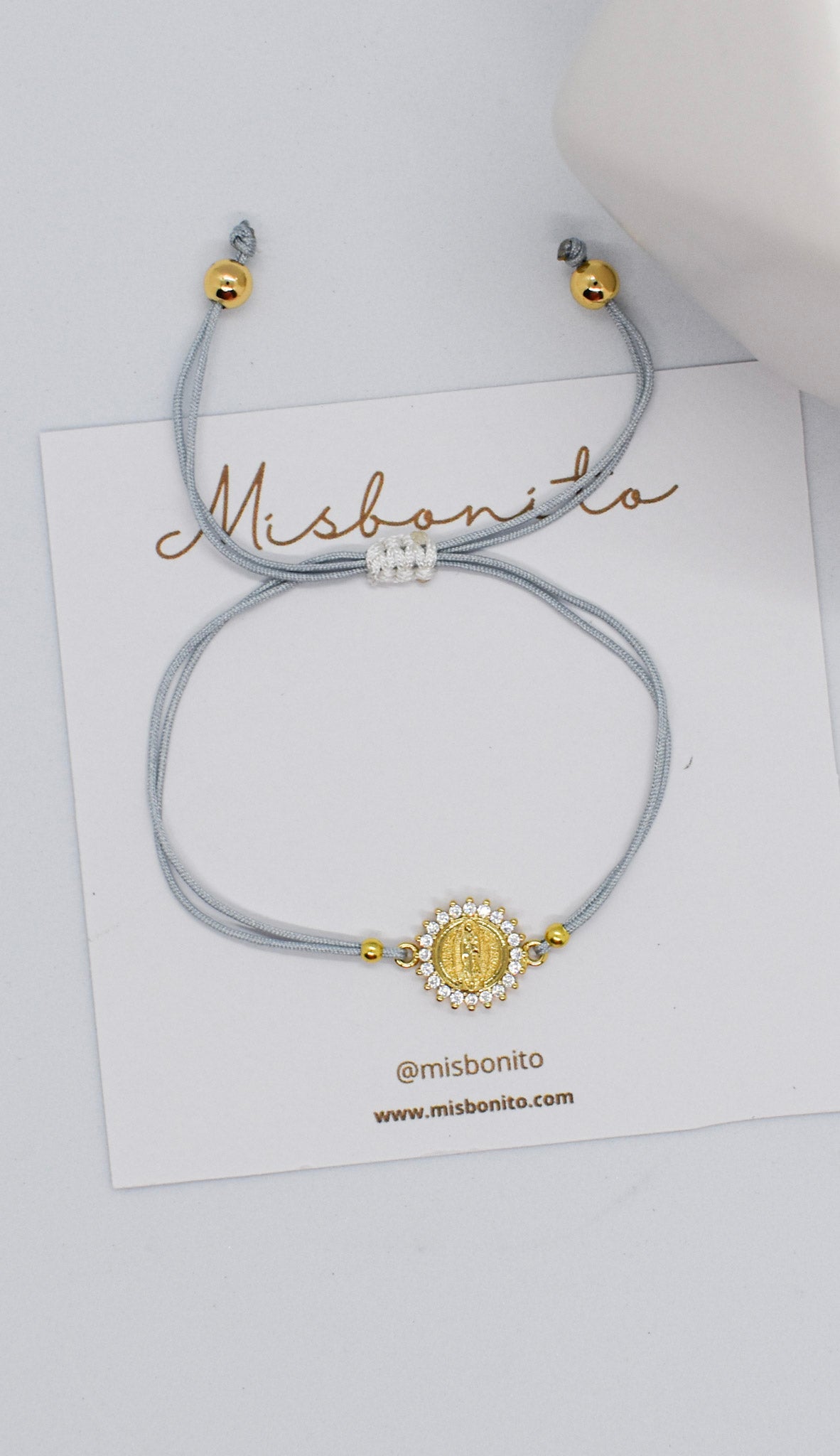 Bracelet with decorative clasp on a white card with 'Misbonito' branding.