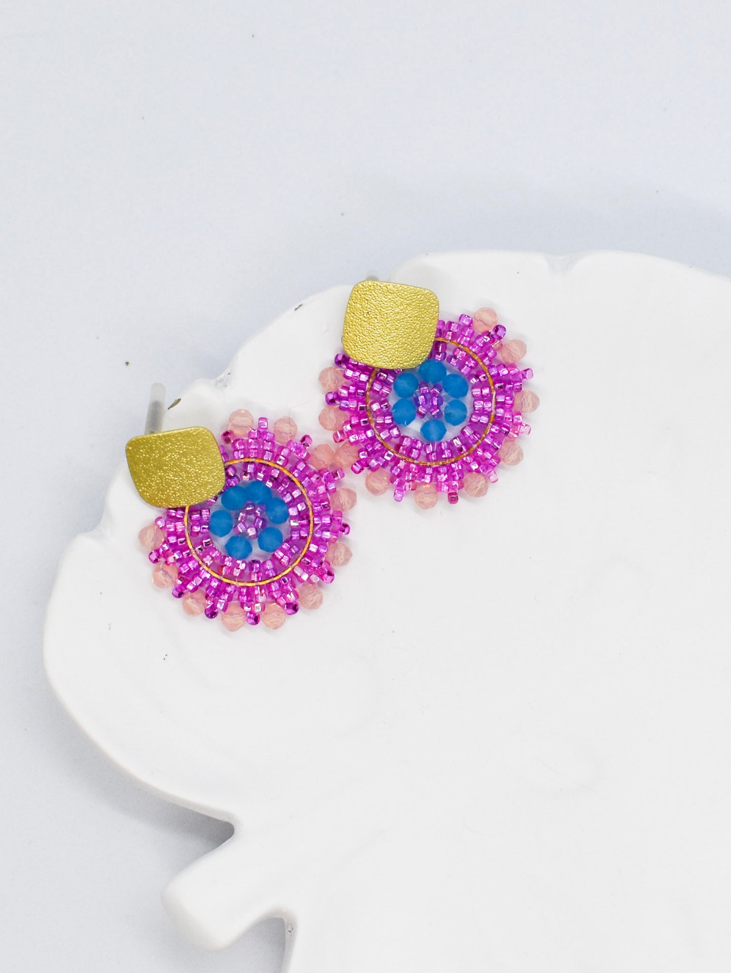 pink beaded round earrings on a white tray