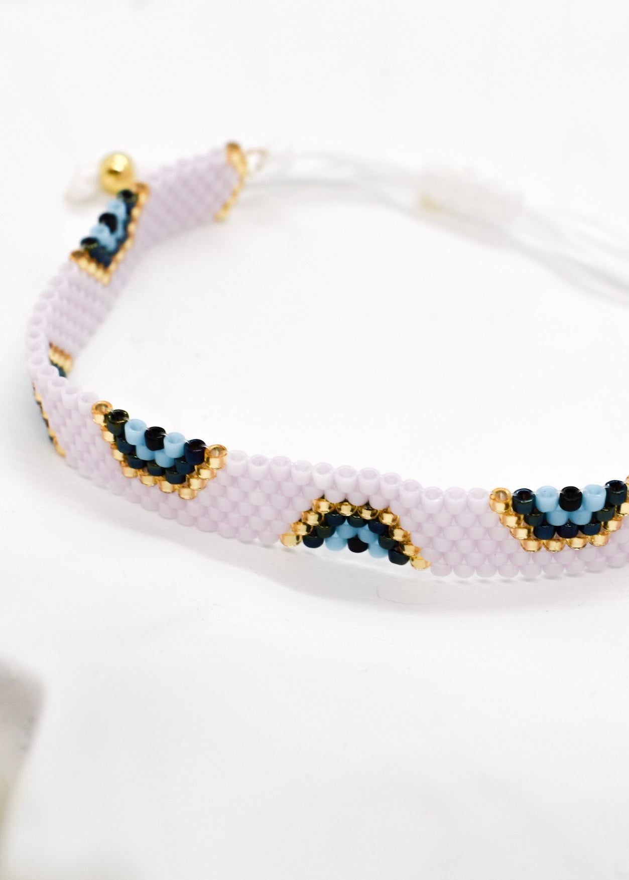 Beaded bracelet with eye designs on a white background