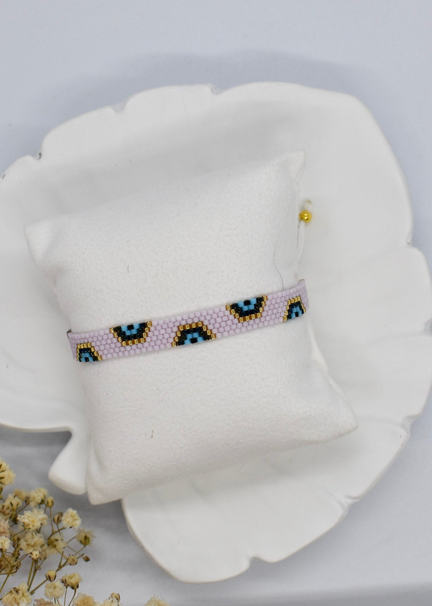 Beaded headband on a pillow with a white background