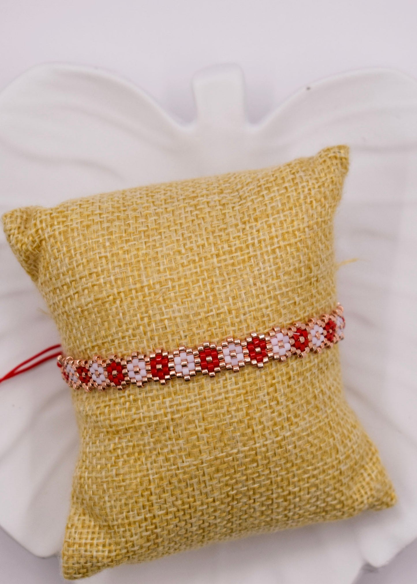 red beaded bracelet on a pillow