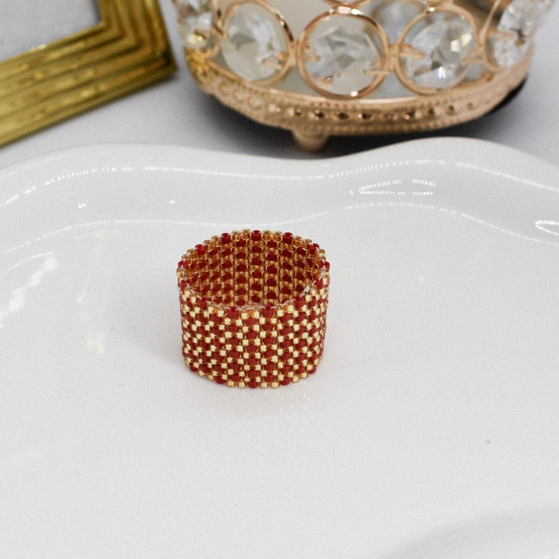 Small decorative object on a white plate with a gold candle holder in the background.
