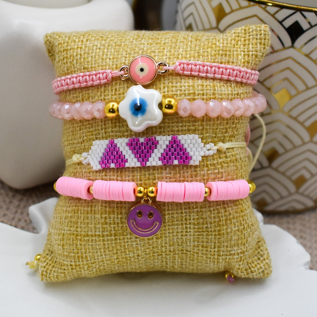 Beaded bracelet with a floral design on a textured pillow against a white background