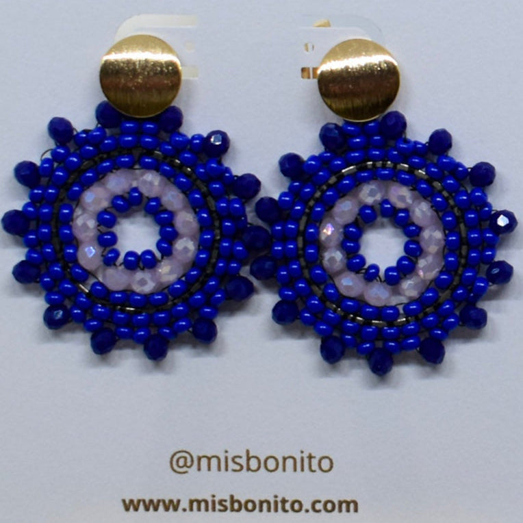 Blue beaded earrings on a Misbonito branded card with flowers in the background