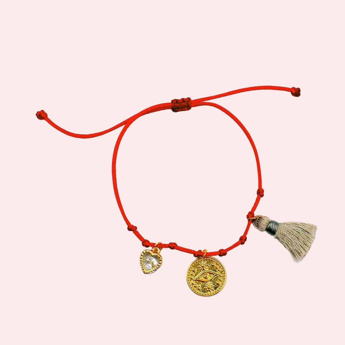 tassel and charms bracelet on a white surface
