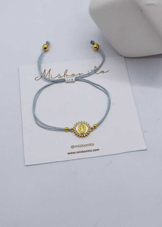 Bracelet with gold accents on a white card with 'Mishonito' branding, on a light gray background.