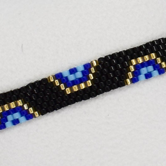 Close-up of a beaded bracelet with blue and gold accents on a light gray background