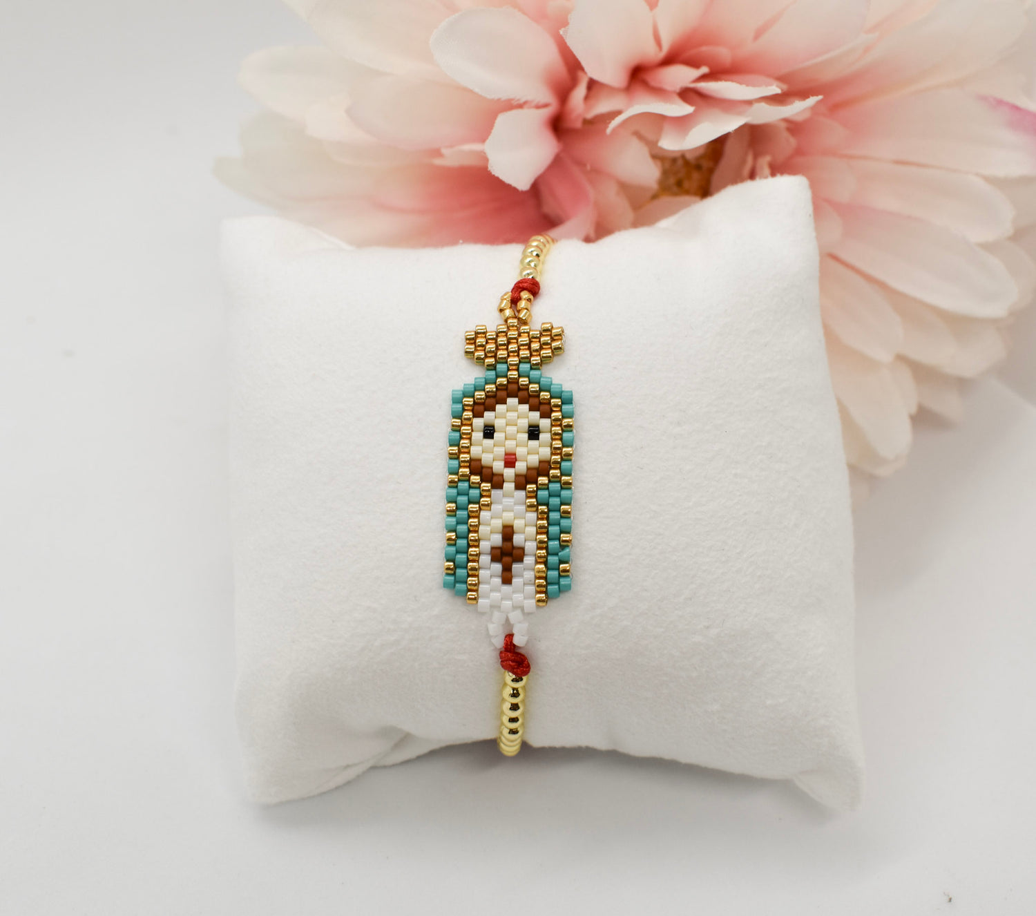 Virgin Mary bracelet on a pillow