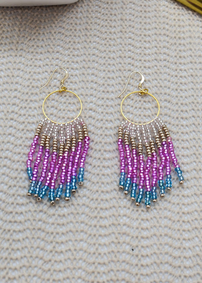 Beaded earrings with gradient colors on a textured surface