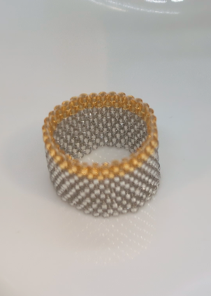 Beaded ring with gold and silver beads on a white background