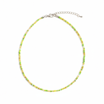 Green beaded necklace on a neutral background
