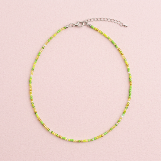 Green beaded necklace on a neutral background