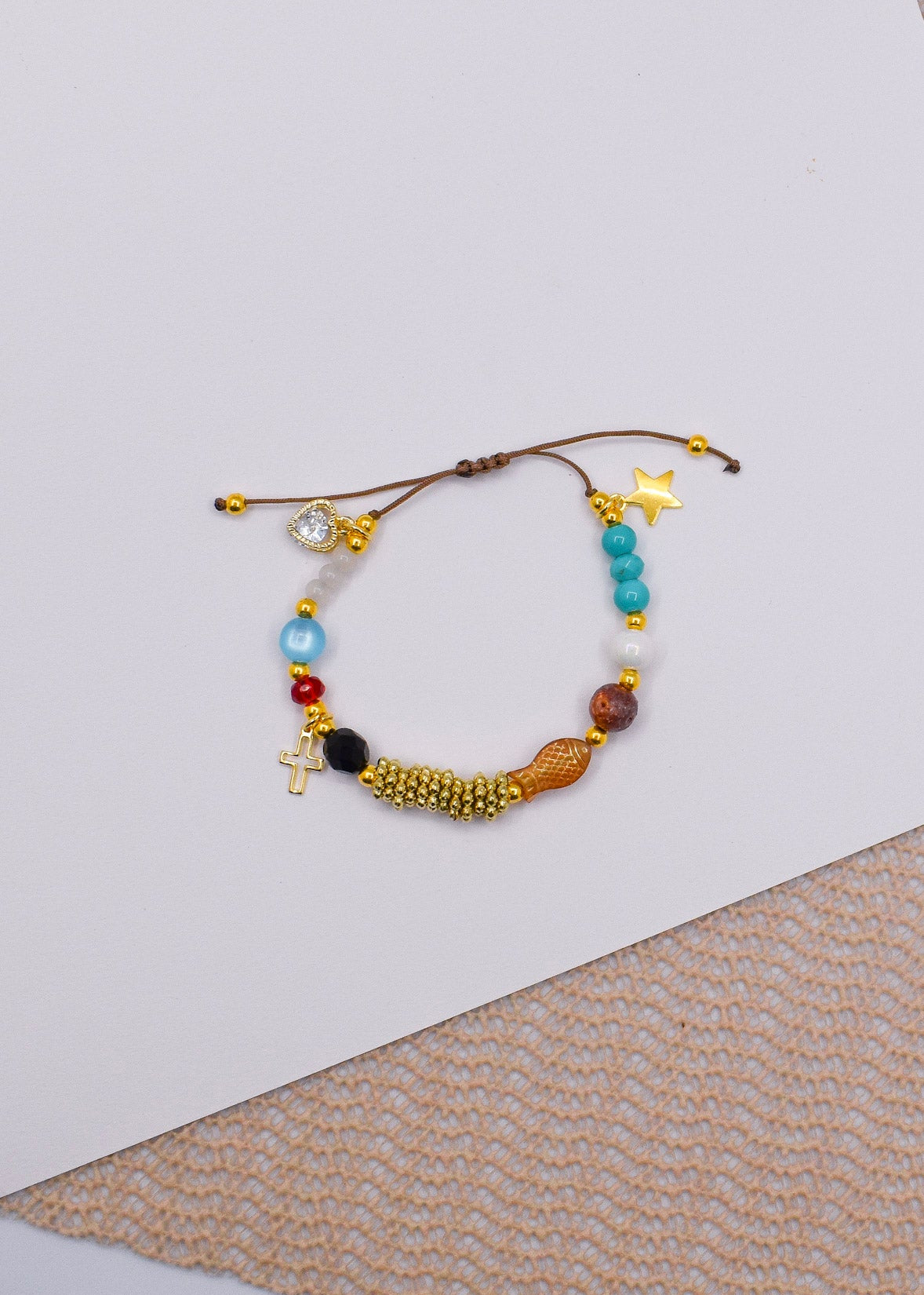 Multicolored Jesus life beaded bracelet on a textured surface