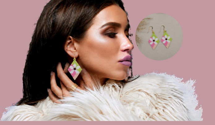 A woman with dark hair and a white faux-fur collar wears pink and green geometric dangle earrings, shown against a dusty pink background with a circular inset of the earrings.