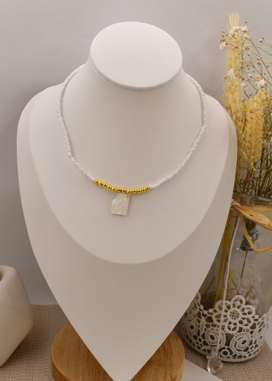 Necklace with a pendant on a white bust against a neutral background
