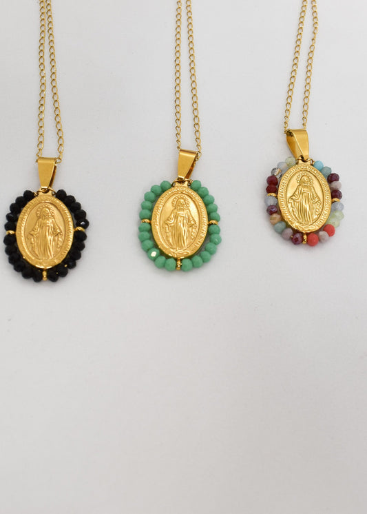 Three gold necklaces with religious pendants on white background