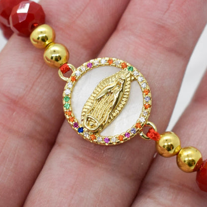 a hand holding a faceted crystal bracelet featuring a colorful zirconia virgin mary 