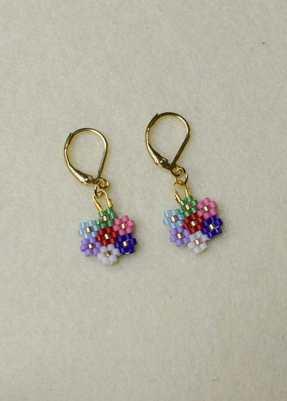 Pair of beaded flower earrings on a beige background