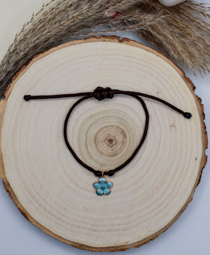brown and blue floral satin bracelet on a wood surface